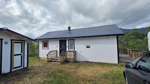A small, single-story house with a front porch and a garage.