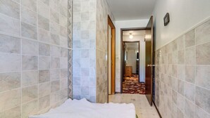 A narrow hallway with tiled walls and a carpeted floor leading to a room. - Private Yard & Patio! Pet-Friendly Lynnwood Home (Lynnwood)