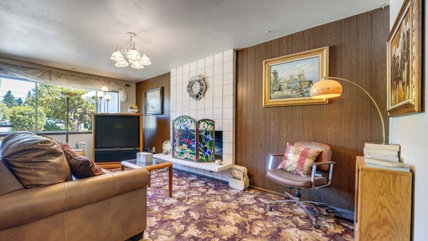 A living room with a sofa, a TV, a fireplace, and a painting on the wall. - Private Yard & Patio! Pet-Friendly Lynnwood Home (Lynnwood)