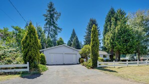 A residential driveway leading to a garage with a white fence on either side. - Private Yard & Patio! Pet-Friendly Lynnwood Home (Lynnwood)