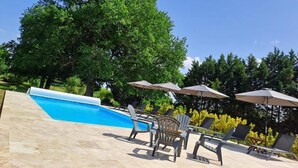A swimming pool with lounge chairs and umbrellas, surrounded by trees. - Mulberry Lodge 16th Century farmhouse in rural setting (Le Fleix)