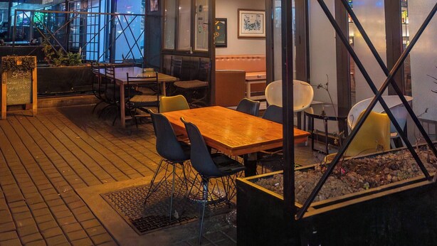 An indoor dining area with hanging plants, a wooden table, and chairs. - The 260 Collection Luxury City Apartment (Johannesburg)
