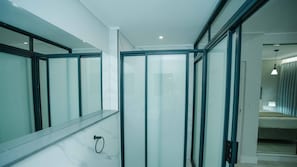 Ein modernes Badezimmer mit Duschkabine aus Glas, Marmorfliesenwand und einem Handtuchhalter.