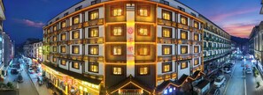 Un hotel de varios pisos con estilo arquitectónico tradicional, que cuenta con balcones y un patio central.