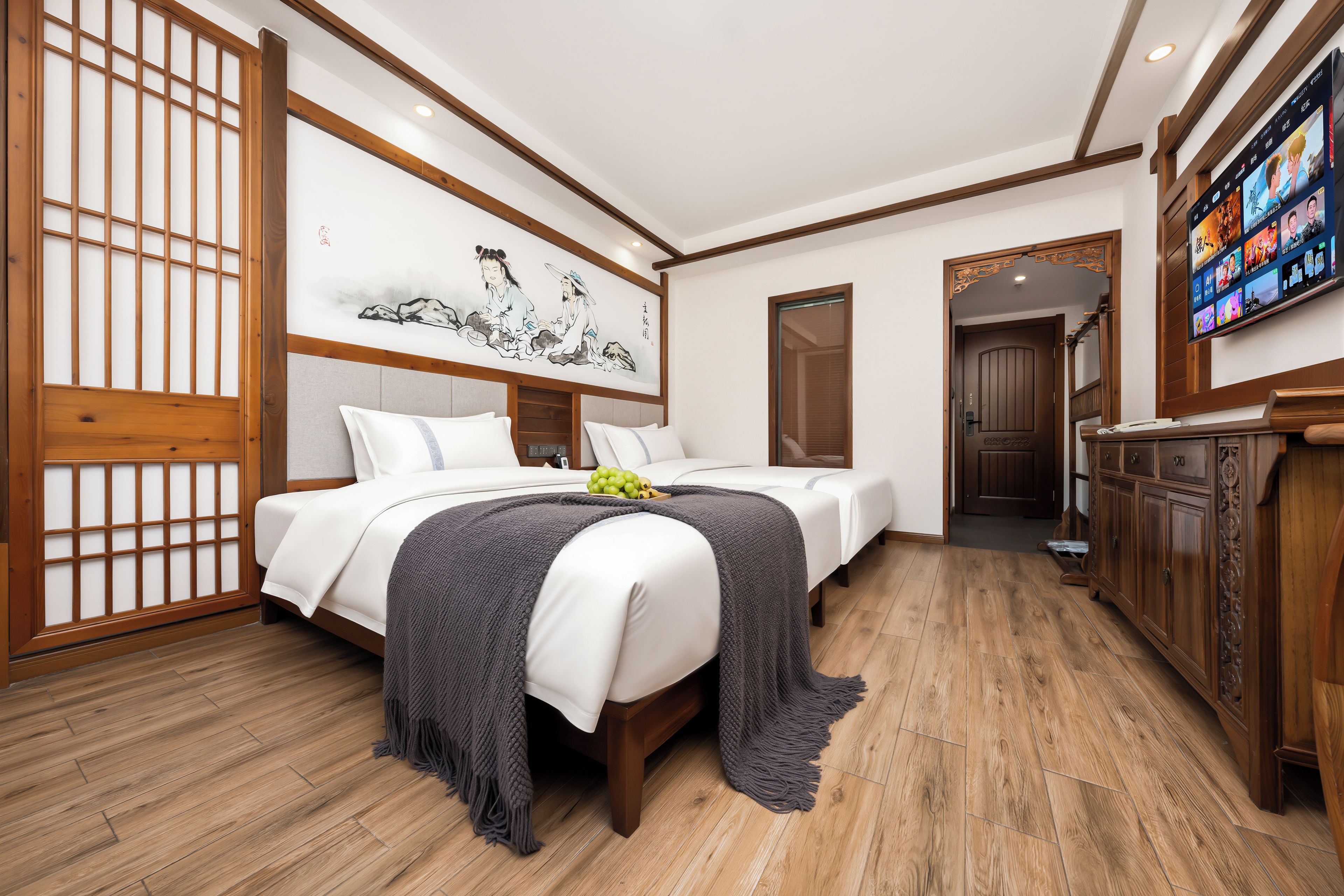 A hotel room with a traditional design, featuring a large bed, a television, and a wooden floor.