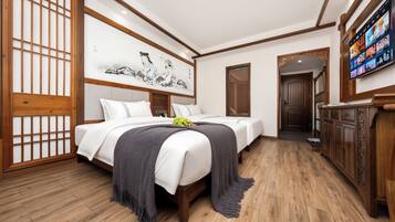 Een hotelkamer met een klassiek design, met een groot bed, een televisie en een houten vloer.