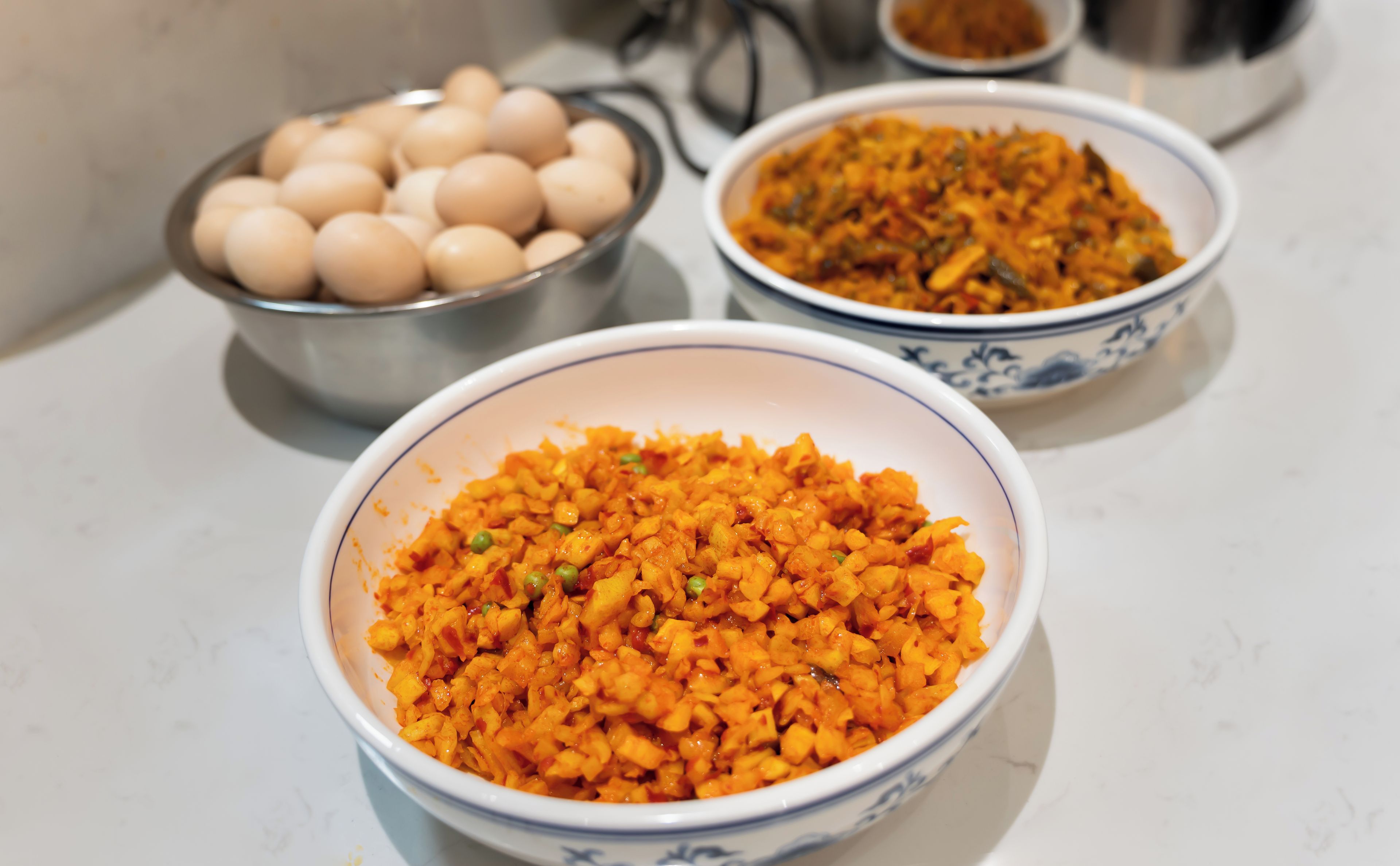 Tres recipientes con comida sobre una encimera.
