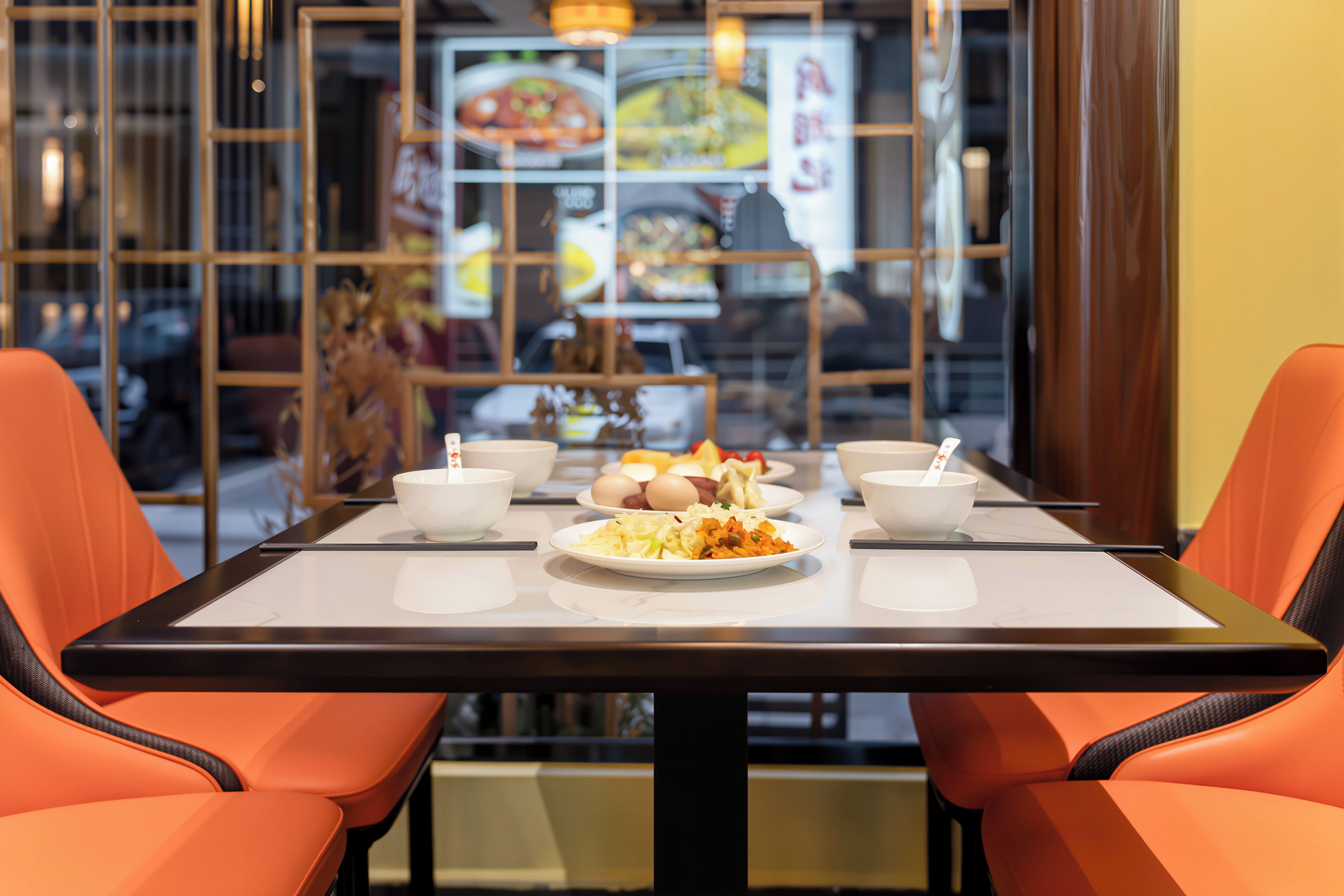 Een restaurantinterieur met een tafel voor twee, met verschillende gerechten en schalen.