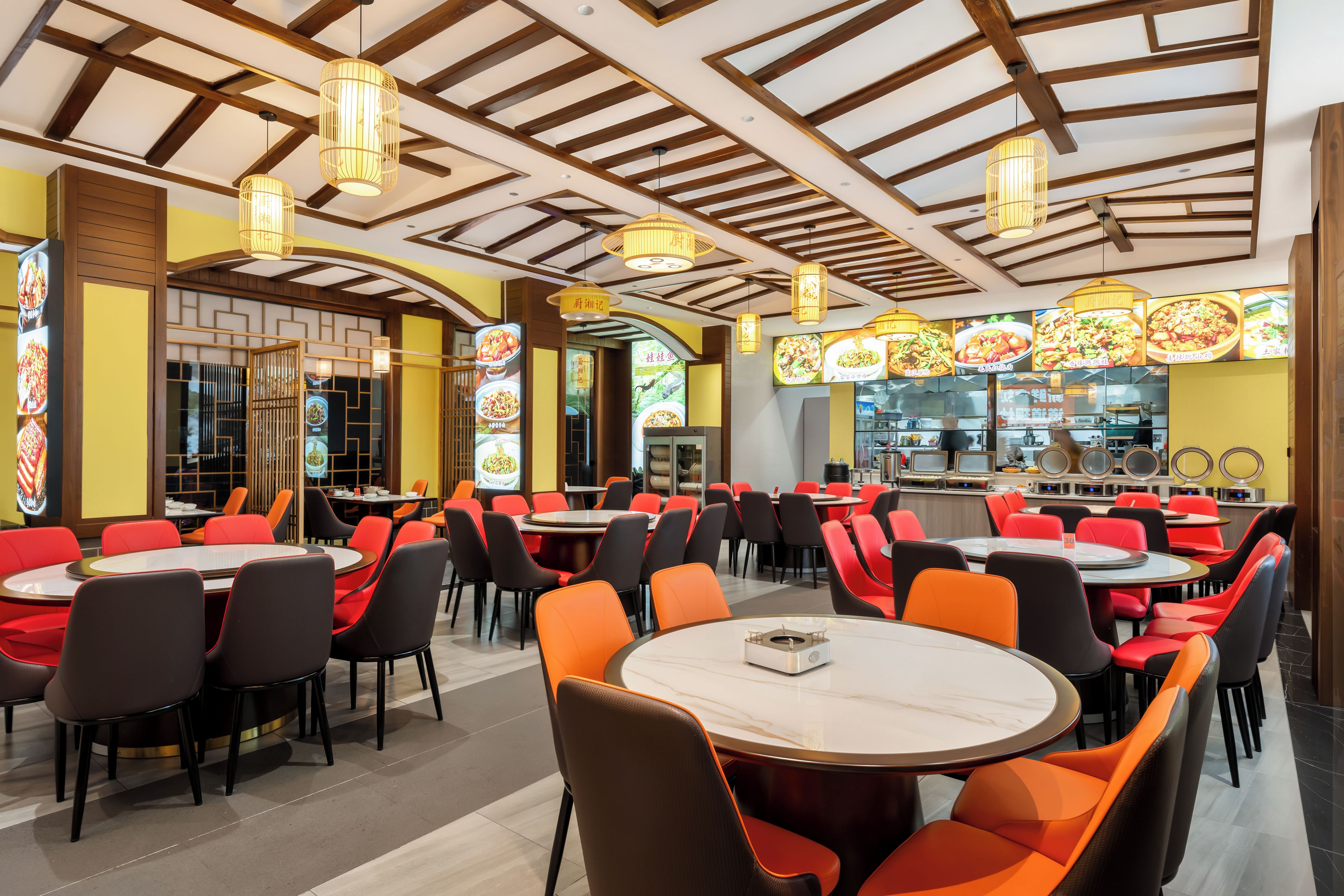 A restaurant with round tables and chairs, wooden ceiling beams, and hanging lights.