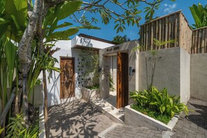Una villa moderna con una puerta de madera, una pared blanca con una ventana y una placa que dice 'VILLA JUNE'.