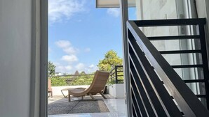 Et moderne interiør med en trappe, der fører op til en balkon.