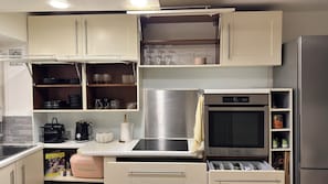 A modern kitchen with a built-in microwave, a stainless steel refrigerator, and a dishwasher. - Stylish Garden Apartment ° Pool, Tennis & Parking ° Near Cannes (Mandelieu-la-Napoule)