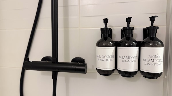 Tres botellas de productos para el cabello colocadas en una pared.