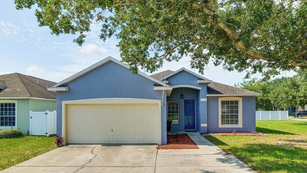 A residential house with a garage, a front door, and a driveway. - Swim, Golf & Park-Hop! Family Home in Davenport (Davenport)