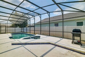 A backyard with a swimming pool, a barbecue grill, and a covered patio area. - Swim, Golf & Park-Hop! Family Home in Davenport (Davenport)
