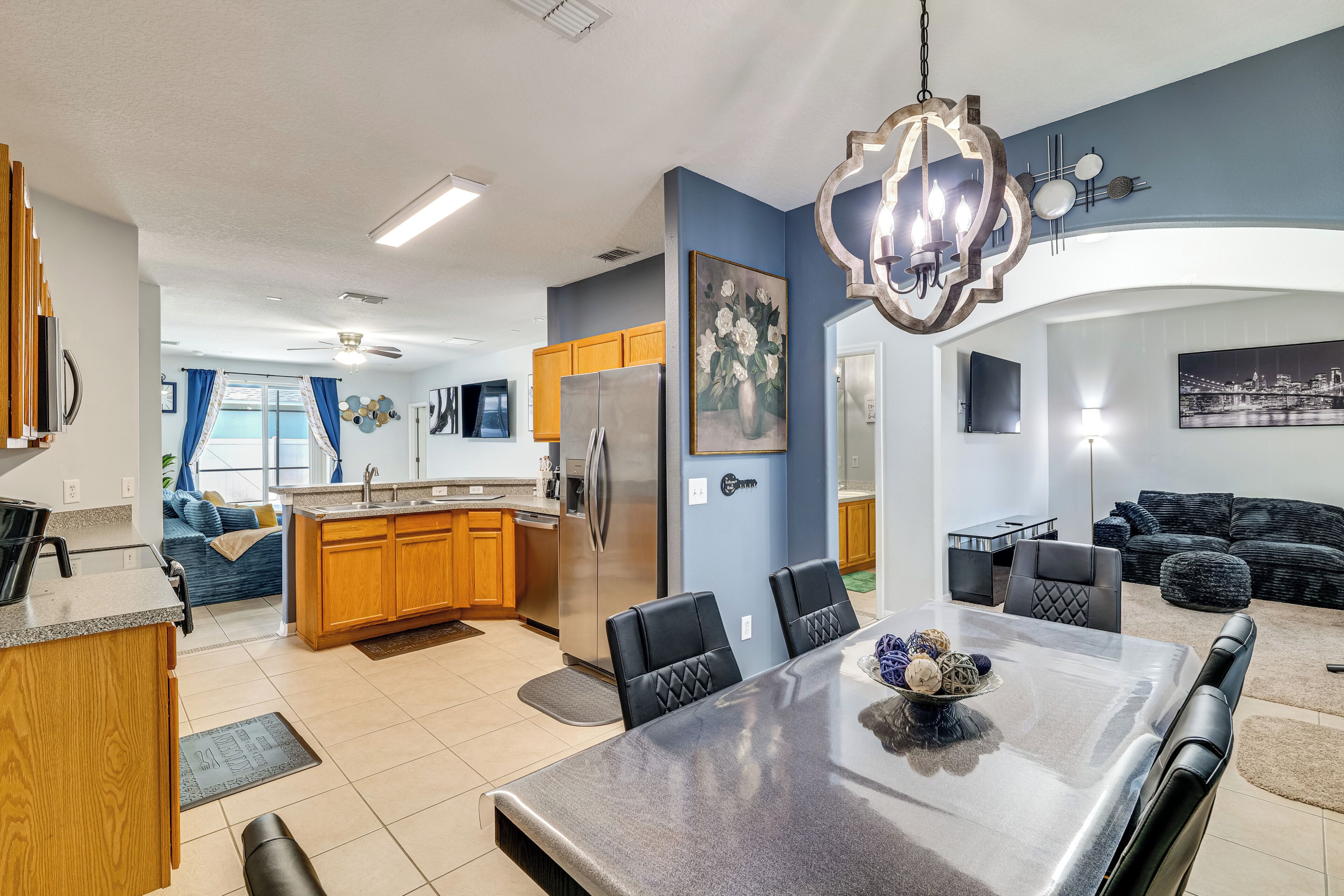 A modern kitchen with a central island, stainless steel appliances, and a dining area with a large table and chairs.