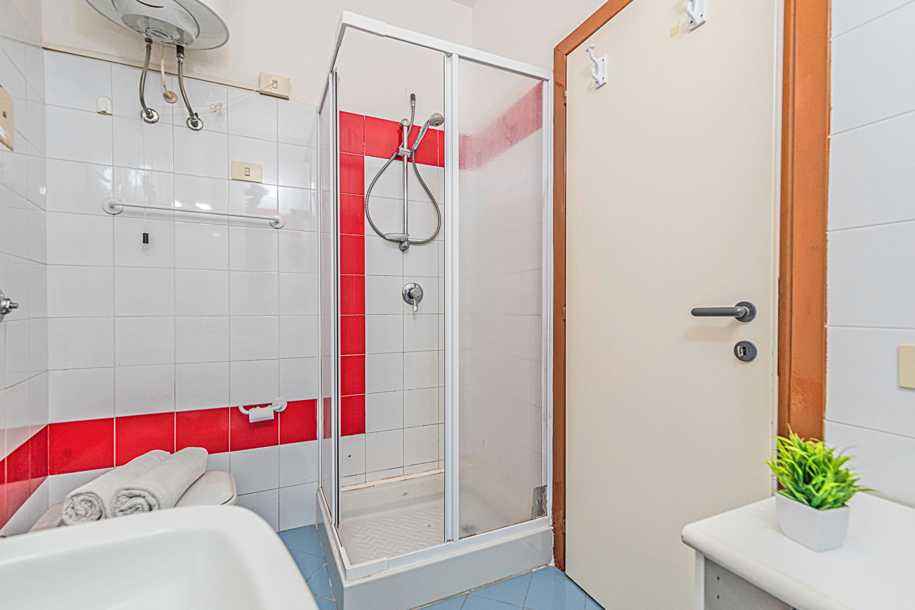 A bathroom with a shower, toilet, and sink.