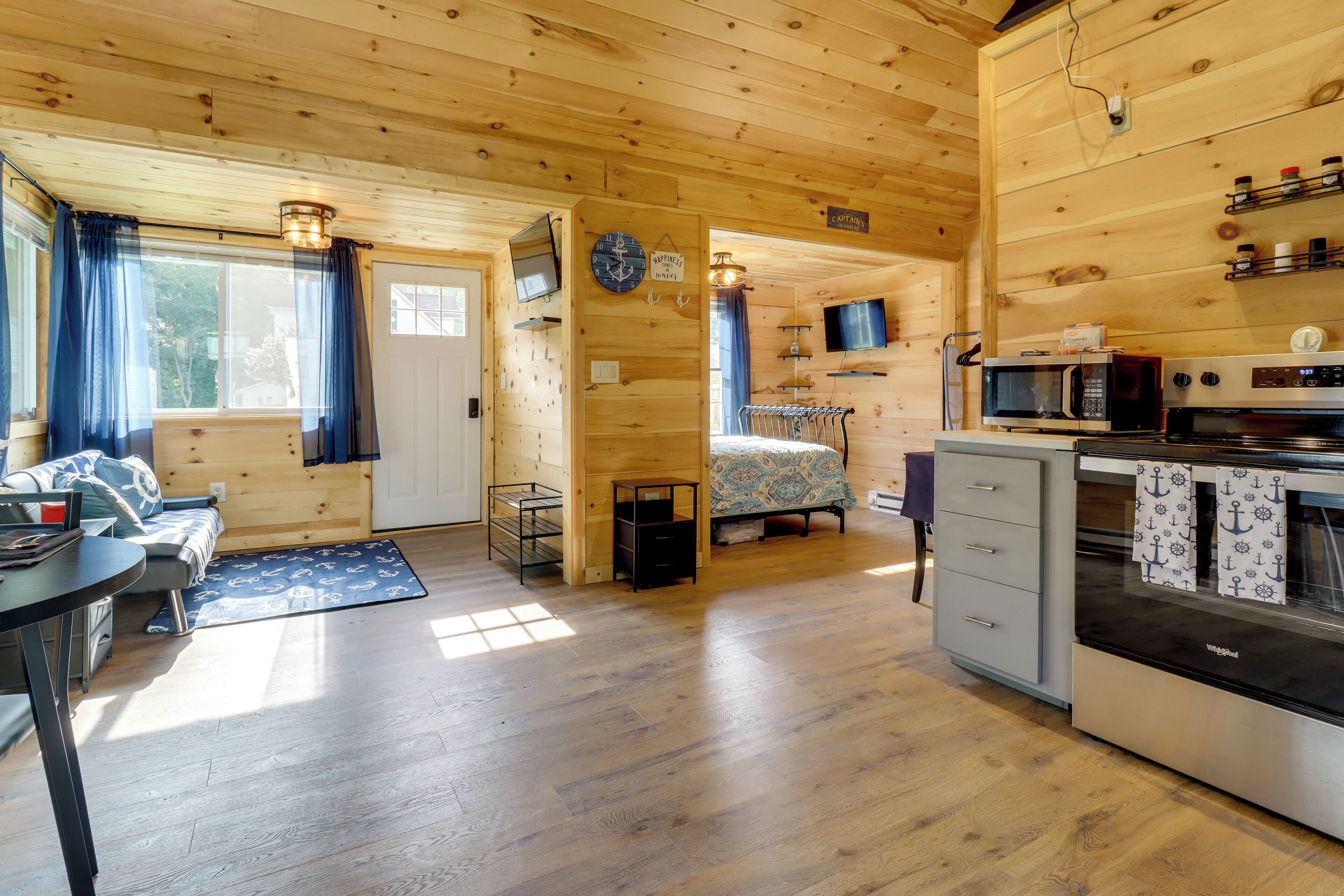 L’intérieur d’un chalet confortable, avec un lit, un coin cuisine et un espace repas.