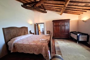 Ein Schlafzimmer mit einem hölzernen Bett, einem Kleiderschrank und einem Nachttisch.
