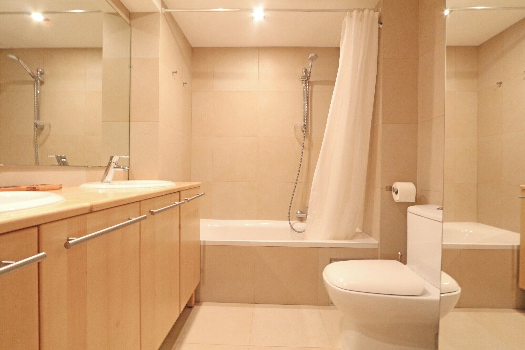 A modern bathroom with a shower, toilet, and vanity.