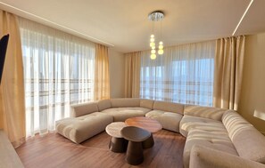 A modern living room with a sectional sofa, a wooden coffee table, and a hanging light fixture. - Awesome home in Drace with sauna (Drace)