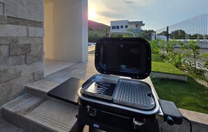 A portable grill with a keyboard on a patio with steps leading to a building. - Awesome home in Drace with sauna (Drace)