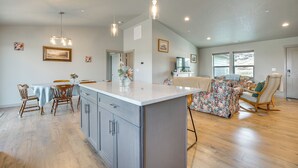Une cuisine spacieuse avec un grand îlot central, des chaises en bois et une table à manger.