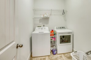 A laundry room with two white washing machines, a shelf with laundry supplies, and a basket. - Walk to Shops & Dining! Quiet Fultondale Home (Fultondale)