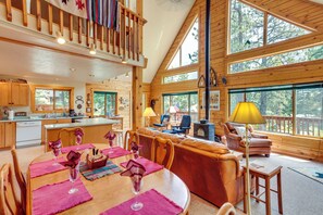 A spacious cabin interior with a dining area, a living room, and a kitchen.
