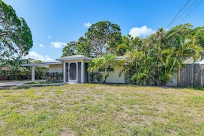 A single-story house with a covered porch, surrounded by a grassy yard and various trees. - Walk to Park & Pool: Sarasota Family Home w/ Yard (Sarasota)