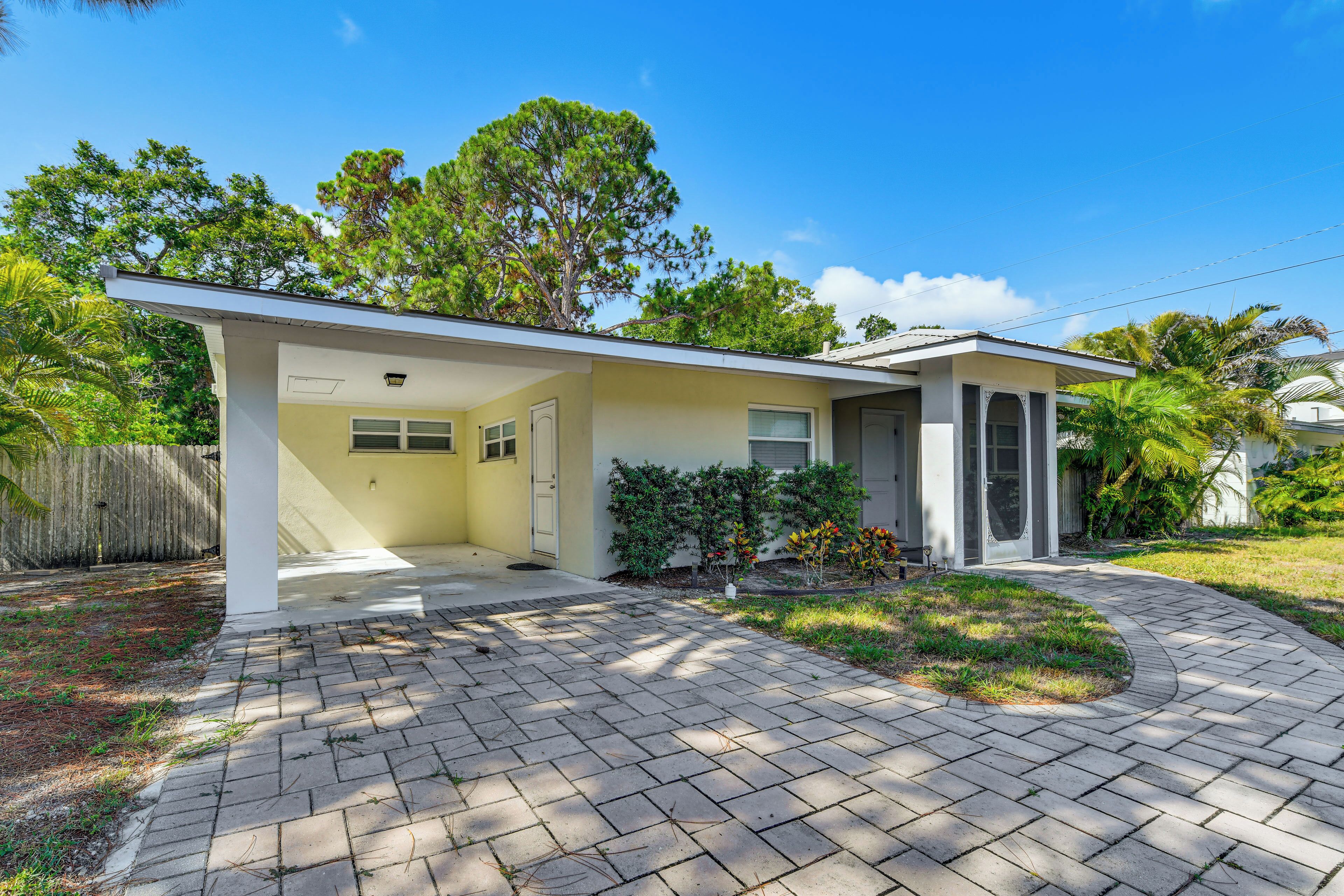 A single-story house with a covered porch, a garage, and a landscaped front yard.