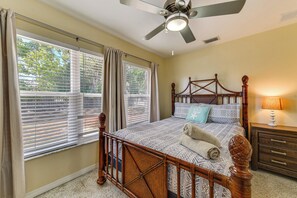 A bedroom with a wooden bed, a ceiling fan, and a nightstand with a lamp. - Walk to Park & Pool: Sarasota Family Home w/ Yard (Sarasota)