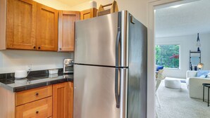 A kitchen with wooden cabinets, a stainless steel refrigerator, and a toaster on the counter. - Walk to Beaches! Lincoln City Family Home w/ Yard (Lincoln City)