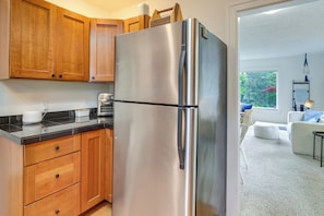 Eine Küche mit Holzausstattung, einem Edelstahl-Kühlschrank und einem Toaster auf der Arbeitsfläche.