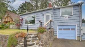 A two-story house with a stone staircase leading to the front door, a garage, and a small porch area with a railing. - Walk to Beaches! Lincoln City Family Home w/ Yard (Lincoln City)
