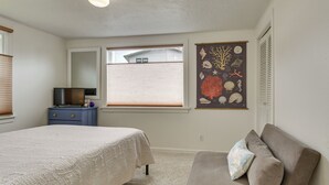 A bedroom with a bed, a dresser, a chair, a window, and a wall art piece. - Walk to Beaches! Lincoln City Family Home w/ Yard (Lincoln City)