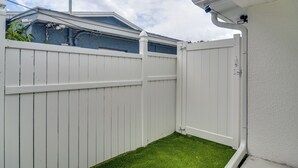Een witte houten schutting met een klein stukje gazon ervoor.