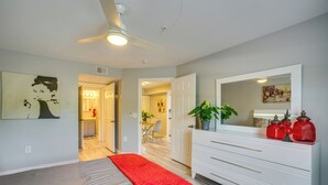 A bedroom with a bed, a dresser, a mirror, and a ceiling fan. - Walk to Shops & Eats! Cape Coral Extended Escape (Cape Coral)