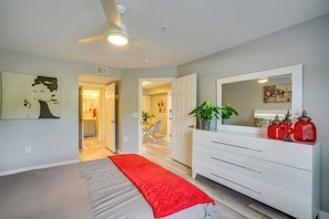 A bedroom with a bed, a dresser, a mirror, and a ceiling fan. - Walk to Shops & Eats! Cape Coral Extended Escape (Cape Coral)