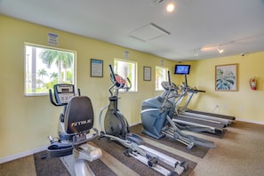 A fitness center with treadmills, an elliptical, and a stationary bike, all equipped with digital displays. - Walk to Shops & Eats! Cape Coral Extended Escape (Cape Coral)
