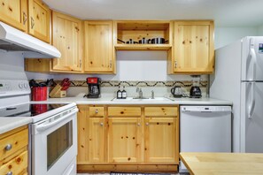 A kitchen with wooden cabinets, a stove, a refrigerator, and a sink. - Hike, Bike & Ski! Cozy Condo 8 Mi to Lake Dillon (Breckenridge)