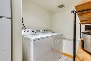 A compact laundry room with a white Whirlpool washer and dryer, a wooden shelf, and a small window. - Hike, Bike & Ski! Cozy Condo 8 Mi to Lake Dillon (Breckenridge)