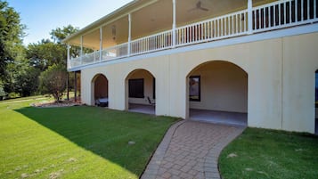 A two-story building with a covered porch and a brick pathway leading to the entrance.