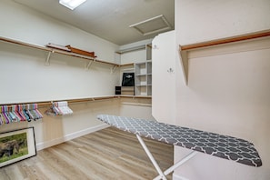 Ein Zimmer mit Holzboden, weißer Wand und einem Holzregal mit einigen Gegenständen darauf.