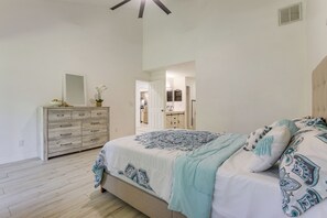 A bedroom with a bed, dresser, and a door leading to a bathroom. - 4 Mi to Sea Turtle Beach! Family Retreat w/ Yard (Jensen Beach)