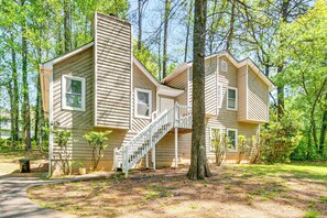 A two-story cabin with a staircase leading to the upper level, surrounded by trees and a dirt path. - Family Getaway in Kennesaw! Spacious Home (Kennesaw)