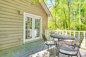 A wooden house with a white door and windows, a porch with a table and chairs, and a white railing. - Family Getaway in Kennesaw! Spacious Home (Kennesaw)
