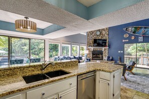 A modern kitchen with granite countertops, a stainless steel dishwasher, and a stone backsplash. - Boat Dock & Slip! Group-Ready Lake Ozark Home (Lake Ozark)