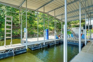 A covered dock area with a ladder, seating, and a small pool. - Boat Dock & Slip! Group-Ready Lake Ozark Home (Lake Ozark)
