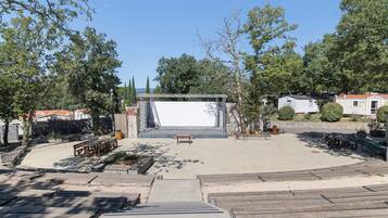 A spacious outdoor area with a stage, seating, and a clear sky.